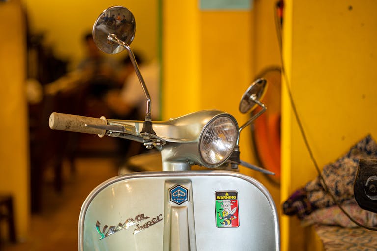 Close-up of a classic Vespa scooter in vibrant, indoor Vietnamese setting.